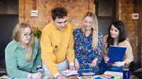 Projektowanie komunikacji i doświadczeń marki | Studia II stopnia w Bydgoszczy | Uniwersytet WSB Merito Bydgoszcz: Grupa studentów pracująca nad projektem