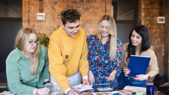 Projektowanie komunikacji i doświadczeń marki | Studia II stopnia w Bydgoszczy | Uniwersytet WSB Merito Bydgoszcz: Grupa studentów pracująca nad projektem