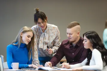 Strona główna | Uniwersytet WSB Merito Bydgoszcz: 4 studentów WSB Merito w Bydgoszczy siedzi przy stole i pracuje nad projektem