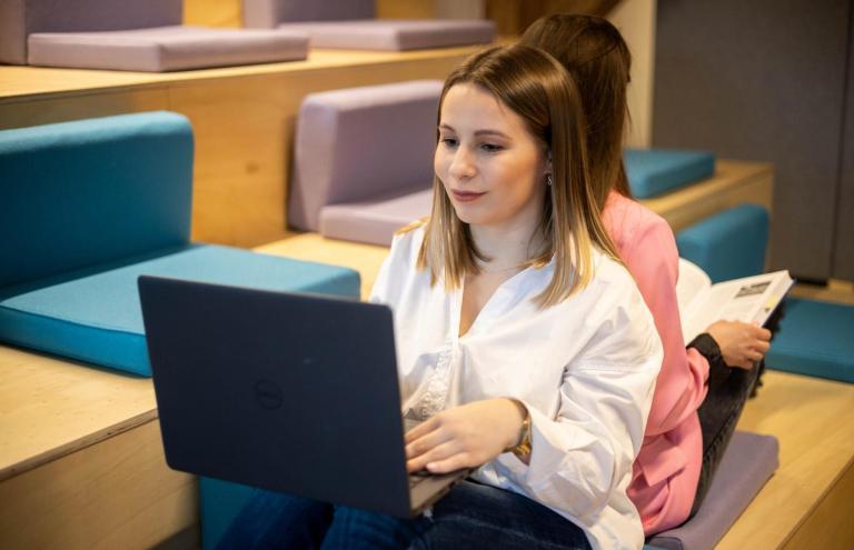 Cyfrowy uniwersytet | Uniwersytet WSB Merito Bydgoszcz: studentka Uniwersytetu WSB Merito Bydgoszcz z laptopem na kolanach