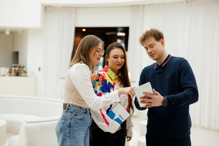 40. Czwartek Social Media 12 marca! [GALERIA ZDJĘĆ] | Aktualności | Uniwersytet WSB Merito Bydgoszcz: trójka studentów przeglądająca tablet