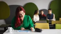 Zarządzanie produkcją | Studia I stopnia w Chorzowie | Uniwersytet WSB Merito Chorzów: studentka analizuje tabelę danych na zajęciach