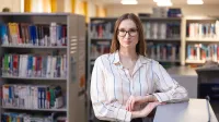 Menedżer produkcji i Lean Manufacturing | Studia II stopnia w Chorzowie | Uniwersytet WSB Merito Chorzów: Studentka stojąca w bibliotece