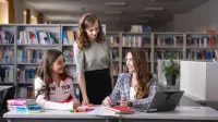 Finanse i rachunkowość | Studia II stopnia w Chorzowie | Uniwersytet WSB Merito Chorzów: Studentki rozmawiające w bibliotece 