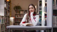 Innowacyjny marketing | Studia I stopnia w Chorzowie | Uniwersytet WSB Merito Chorzów: Studentka czytająca książkę w bibliotece