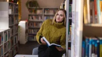 Innovative Marketing | Studia I stopnia w Chorzowie | Uniwersytet WSB Merito Chorzów: studentka przeglądająca książki w bibliotece 