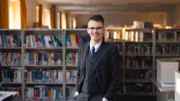 Menedżer przedsiębiorstwa | Studia II stopnia w Chorzowie | Uniwersytet WSB Merito Chorzów: Student stojący w bibliotece