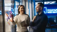 Psychologia skutecznej sprzedaży | Studia podyplomowe w Chorzowie | Uniwersytet WSB Merito Chorzów: Studenci rozmawiają na korytarzu