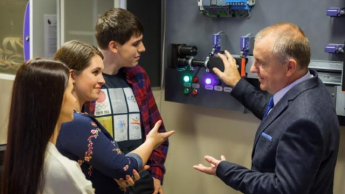 Inteligentne systemy logistyczne | Studia I stopnia w Chorzowie | Uniwersytet WSB Merito Chorzów: studenci omawiający sprzęt logistyczny z wykładowcą