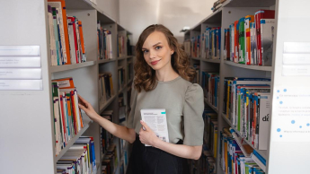 Obsługa ruchu lotniczego | Studia I stopnia w Chorzowie | Uniwersytet WSB Merito Chorzów: studentka przegląda książki w bibliotece