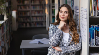 Psychologia menedżera | Studia I stopnia w Chorzowie | Uniwersytet WSB Merito Chorzów: Studentka stojąca w bibliotece 