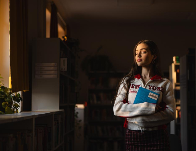 Strategie i techniki sprzedaży w modelu omnichannel | Studia I stopnia w Chorzowie | Uniwersytet WSB Merito Chorzów: Studentka stojąca w bibliotece