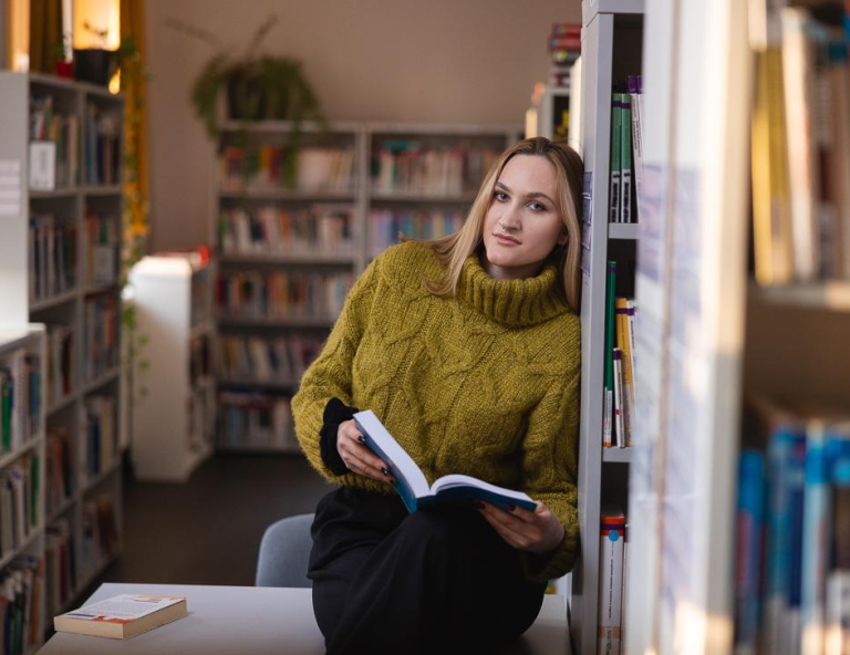 Finanse i rachunkowość | Studia II stopnia ze studiami podyplomowymi w Chorzowie | Uniwersytet WSB Merito Chorzów: studentka przeglądająca książki w bibliotece 