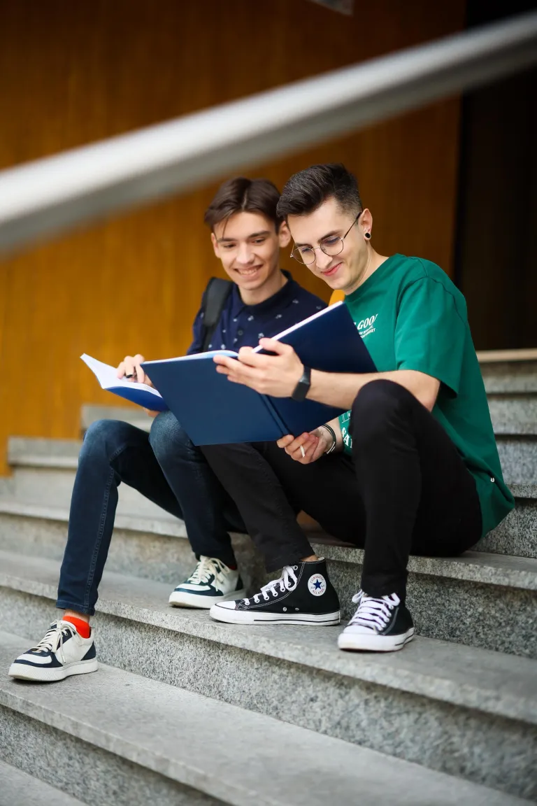 Zarządzanie | Studia I stopnia w Chorzowie | Uniwersytet WSB Merito Chorzów: Dwóch studentów na schodach z książką