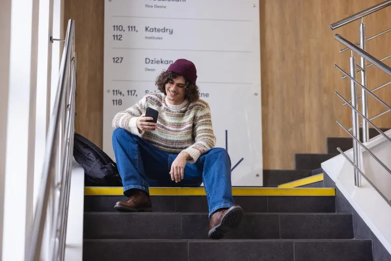 Zarządzanie - dla inżynierów | Studia II stopnia w Chorzowie | Uniwersytet WSB Merito Chorzów: student siedzący na korytarzu uczelni