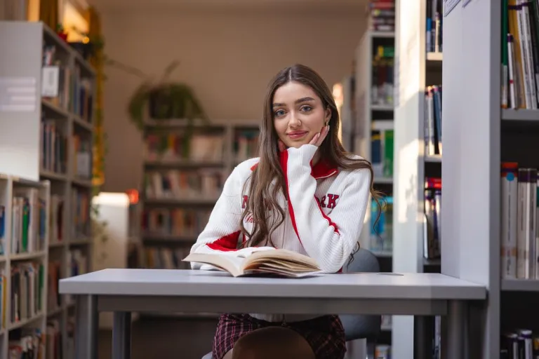 Zarządzanie sprzedażą | Studia I stopnia w Chorzowie | Uniwersytet WSB Merito Chorzów: Studentka czytająca książkę w bibliotece
