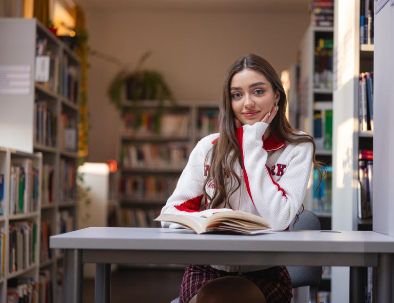 Library | WSB Merito University in Chorzów: Studentka czytająca książkę w bibliotece