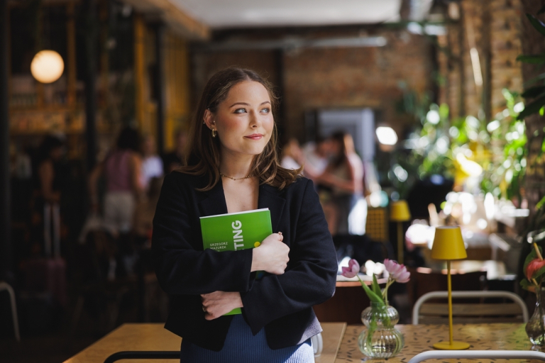 The student ABC | WSB Merito Gdańsk University: Grafika główna: WSB Merito Gdańsk, dla nowych studentów, studentka w kawiarni trzyma książkę