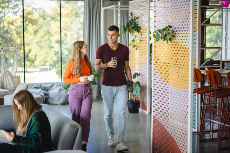Our values | WSB Merito Wrocław University: Główna grafika: poznaj WSB Merito Wrocław - studentka i student idą korytarzem uczelni