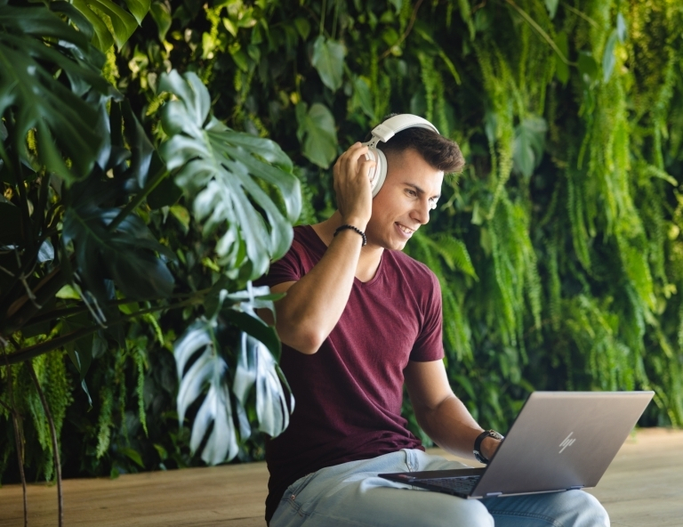 Preparatory language courses for international students | WSB Merito Wrocław University: A man wearing headphones holding a laptop podcast