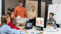 Marketing i sprzedaż | Studia I stopnia w Gdańsku | Uniwersytet WSB Merito w Gdańsku: Studenci pracują w grupie na warsztatach. Korzystają z tablicy, laptopa, komputera i kartek