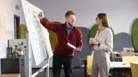 Global finance | Studia I stopnia w Gdańsku | Uniwersytet WSB Merito w Gdańsku: Wykładowca tłumaczy studentce temat przy tablicy