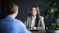 Zarządzanie zasobami ludzkimi | Studia I stopnia w Gdańsku | Uniwersytet WSB Merito w Gdańsku: Zdjęcie z rozmowy pomiędzy kobietą a mężczyzną przy biurku