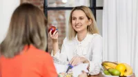 Dietetyka | Studia I stopnia w Gdańsku | Uniwersytet WSB Merito w Gdańsku: Studentka rozmawia i trzyma w ręku jabłko