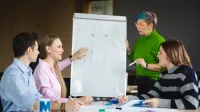 Marketing i sprzedaż | Studia II stopnia w Gdańsku | Uniwersytet WSB Merito w Gdańsku: Słuchacze sp z wykładowcą rozwiązują case przy flipcharcie