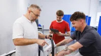 Medycyna stylu życia | Studia I stopnia w Gdańsku | Uniwersytet WSB Merito w Gdańsku: Medyk sprawdza wyniki na rowerku pacjenta