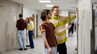 Zarządzanie usługami premium | Studia II stopnia w Gdańsku | Uniwersytet WSB Merito w Gdańsku: Studenci w korytarzu podczas warsztatów 