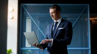 Doradca w procesie sukcesji | Studia podyplomowe w Gdańsku | Uniwersytet WSB Merito w Gdańsku: Słuchacz w garniturze i z laptopem w ręku