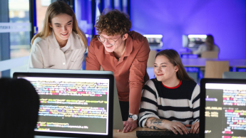 Informatyka | Studia I stopnia w Gdańsku | Uniwersytet WSB Merito w Gdańsku: Studenci siedzą przy stacjonarnych monitorach i coś kodują