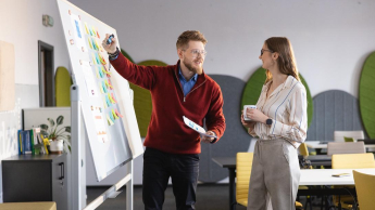 Global finance | Studia I stopnia w Gdańsku | Uniwersytet WSB Merito w Gdańsku: Wykładowca tłumaczy studentce temat przy tablicy