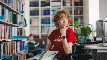 Psychologia w zarządzaniu z certyfikatem FU | Studia II stopnia ze studiami podyplomowymi  | Uniwersytet WSB Merito w Gdańsku: Studentka czyta książkę w bibliotece