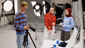 Komunikacja cyfrowa i media kreatywne | Studia II stopnia w Gdańsku | Uniwersytet WSB Merito w Gdańsku: Studenci w studio fotograficznym robią zdjęcia produktom