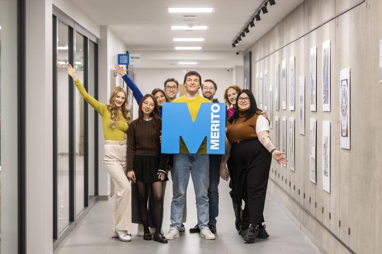 Studia I stopnia w Gdańsku | Uniwersytet WSB Merito w Gdańsku: Zdjęcie grupowe studentów na korytarzu z sygnetem "M"