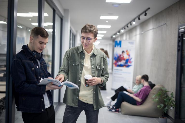 Bezpieczeństwo wewnętrzne | Studia II stopnia w Gdańsku | Uniwersytet WSB Merito w Gdańsku: Studenci stoją w korytarzu i uczą się na zajęcia