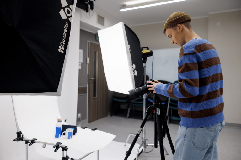 Fotografia i animacja cyfrowa | Studia I stopnia w Gdańsku | Uniwersytet WSB Merito w Gdańsku: Student podczas wykonywania zdjęć produktowych w studio