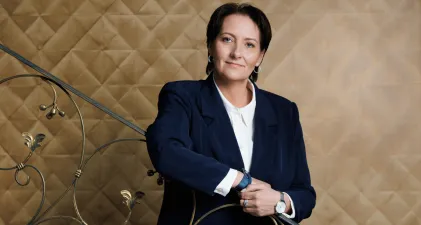 Władze uniwersytetu | Uniwersytet WSB Merito w Gdańsku: Kobieta opierająca się o ramę schodów. Ma ona krótkie włosy i ubrana jest w garnitur