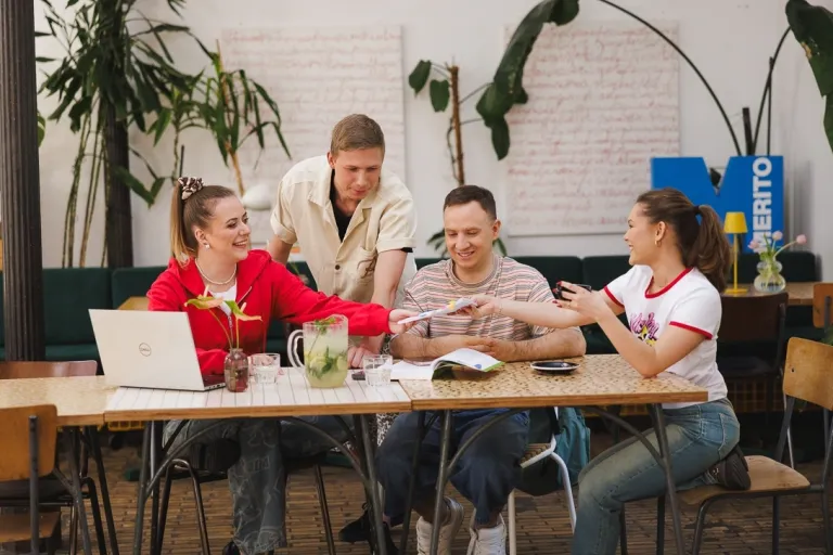 FinTech i Big Data | Studia II stopnia w Gdańsku | Uniwersytet WSB Merito w Gdańsku: Studenci w kawiarni pracują w grupie przy projekcie