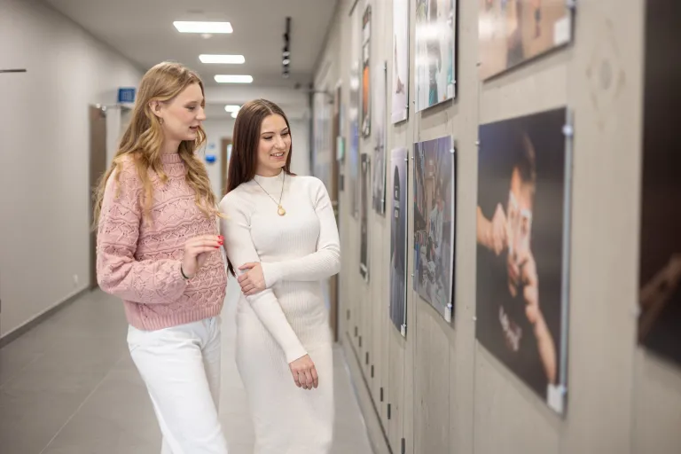 Kreowanie treści w mediach cyfrowych | Studia II stopnia ze studiami podyplomowymi  | Uniwersytet WSB Merito w Gdańsku: Studentki oglądają wystawę na galerii na Uczelni 