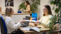 Employer Branding | Studia podyplomowe w Gdyni | Uniwersytet WSB Merito Gdynia: Dwie kobiety załatwiają formalności na Uniwersytecie