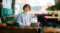 Administracja morska i bezpieczeństwo portowe | Studia I stopnia w Gdyni | Uniwersytet WSB Merito Gdynia: Student w kawiarni przy laptopie