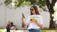 Zarządzanie zasobami ludzkimi z certyfikatem Franklin Univeristy | Studia podyplomowe w Gdyni | Uniwersytet WSB Merito Gdynia: Studentka w parku z komórką w dłoni