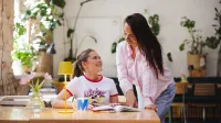 Zarządzanie projektami | Uniwersytet WSB Merito Gdynia: Dziewczyna pochyla się nad stołem przy, którym siedzi studentka