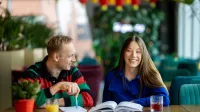 Prompting i optymalizacja systemów AI | Studia I stopnia w Gdyni | Uniwersytet WSB Merito Gdynia: Student i studentka nad książką