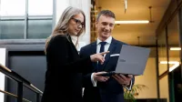 Doradca w procesie sukcesji | Uniwersytet WSB Merito Gdynia: Zdjęcie z sesji biznesowej, na którym znajduje się kobieta i mężczyzna w biznesowym ubraniu i w loftowej przestrzeni 
