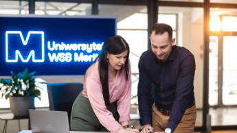 Marketing kultury | Uniwersytet WSB Merito Gdynia: dwie osoby stojące przy stole pracujące nad projektem