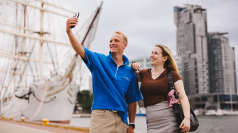 Systemy transportowe | Studia I stopnia w Gdyni | Uniwersytet WSB Merito Gdynia: Para studentów robi sobie selfie na tle Sea Tower w Gdyni